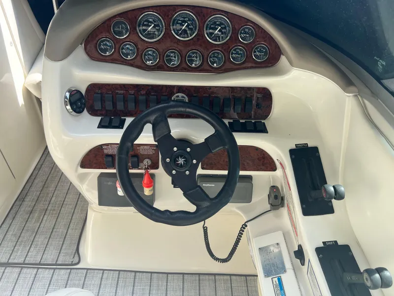 Slide: The Image of Dashboard of a 2000 Sea Ray 280 Bowrider boat with steering wheel and controls. - 13