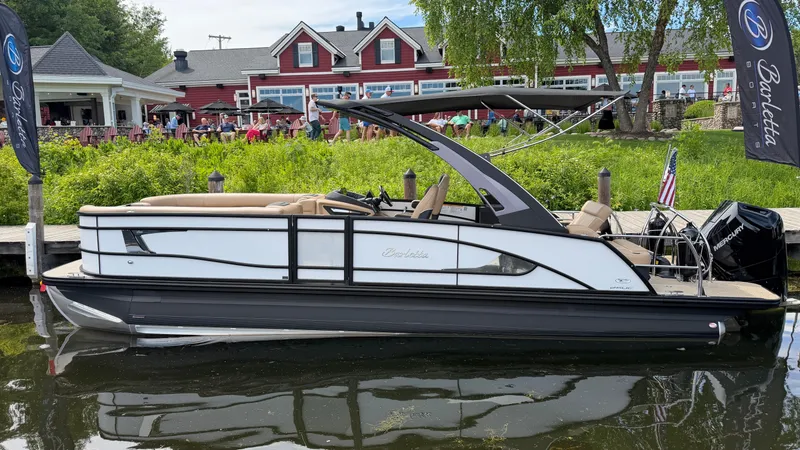 Slide: The Image of Barletta LUSSO 25 UCA 2026: Sleek pontoon boat docked, featuring modern seating and engine. - 0