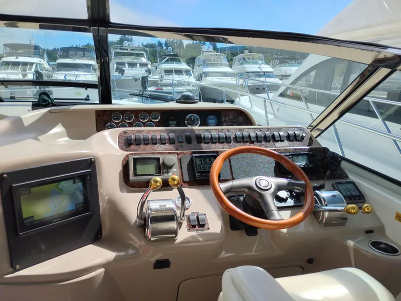 Slide: The Image of Cockpit view of a 1999 Sea Ray 400 Sundancer yacht with steering wheel and controls. - 12