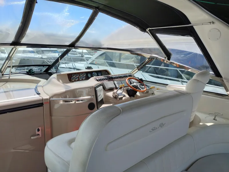 Slide: The Image of 1999 Sea Ray 400 Sundancer yacht cockpit with steering wheel and control panel. - 13