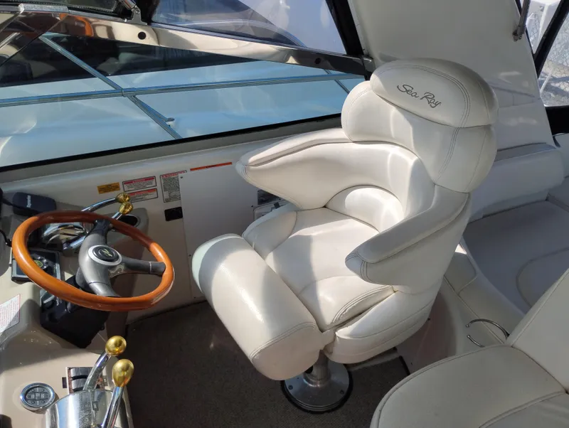 Slide: The Image of Captain's chair and helm of 1999 Sea Ray 400 Sundancer yacht, featuring a wooden steering wheel. - 14