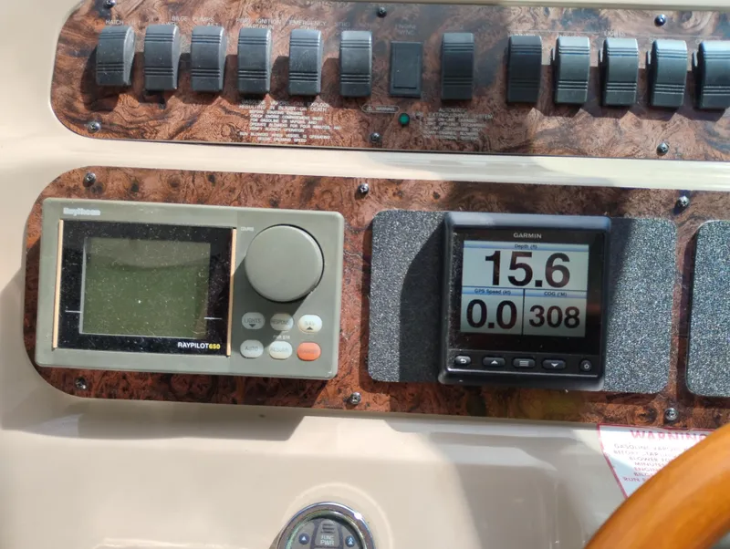 Slide: The Image of Control panel of a 1999 Sea Ray 400 Sundancer with navigation instruments and switches. - 18