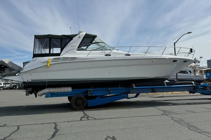 Slide: The Image of 1999 Sea Ray 400 Sundancer yacht on trailer at marina, under clear sky. - 2