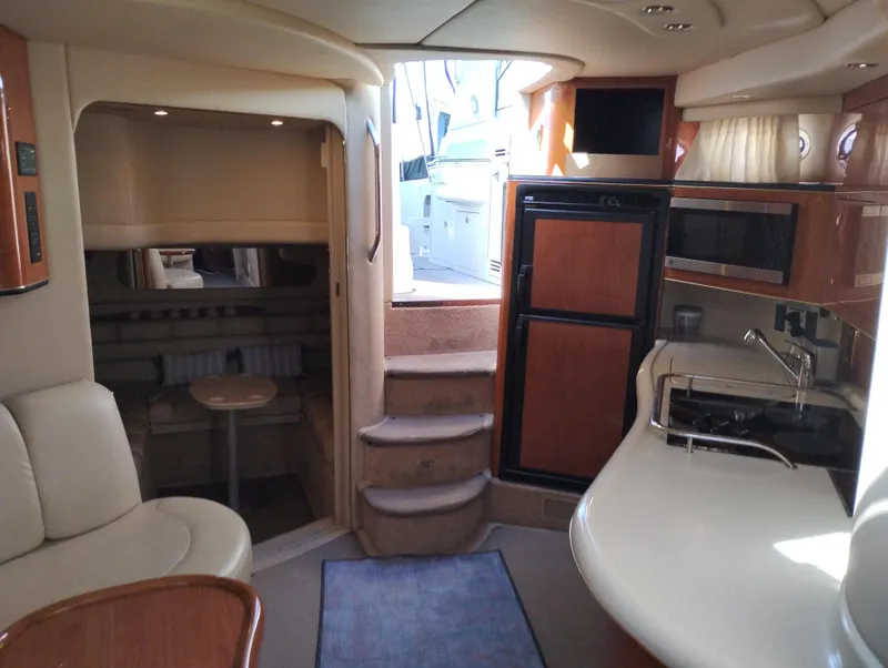 Slide: The Image of Interior of 1999 Sea Ray 400 Sundancer yacht with kitchen and seating area. - 22