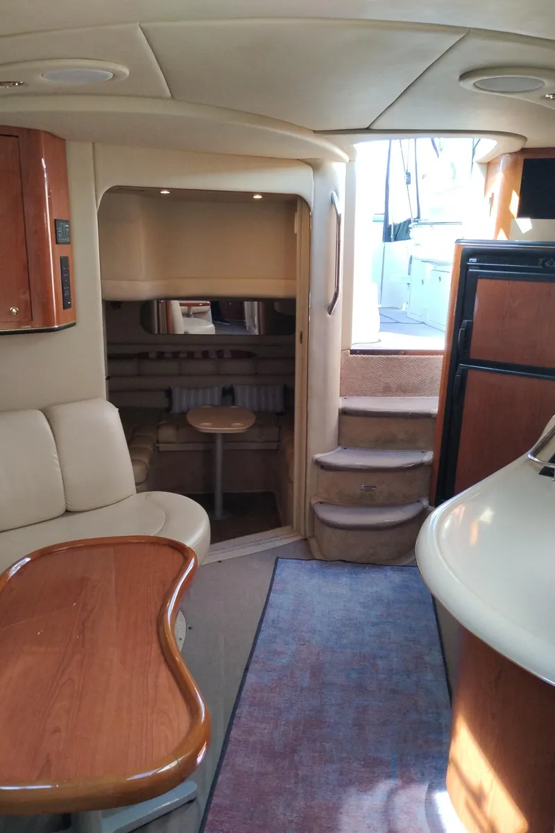 Slide: The Image of Interior of 1999 Sea Ray 400 Sundancer yacht with seating, table, and steps to deck. - 23