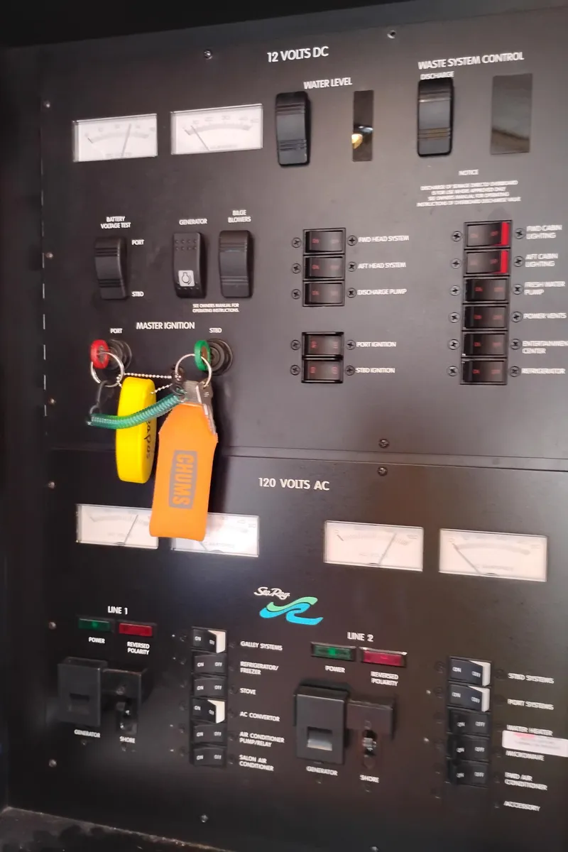 Slide: The Image of Control panel of a 1999 Sea Ray 400 Sundancer boat, featuring various switches and gauges. - 26