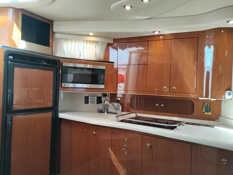 Slide: The Image of Interior of 1999 Sea Ray 400 Sundancer yacht kitchen with wood cabinets and modern appliances. - 29