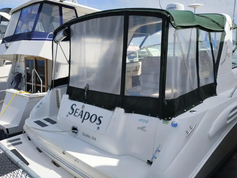 Slide: The Image of 1999 Sea Ray 400 Sundancer docked, featuring a green canopy and "Seapos" nameplate. - 3