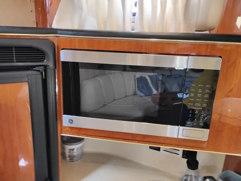 Slide: The Image of Microwave in 1999 Sea Ray 400 Sundancer yacht kitchen, featuring wood paneling and modern appliances. - 30