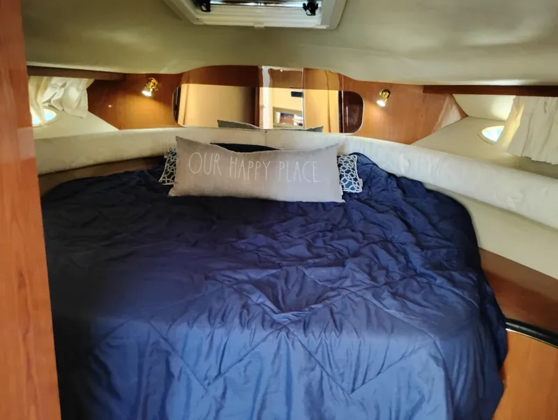 Slide: The Image of Cozy cabin interior of 1999 Sea Ray 400 Sundancer with blue bedding and decorative pillow. - 34