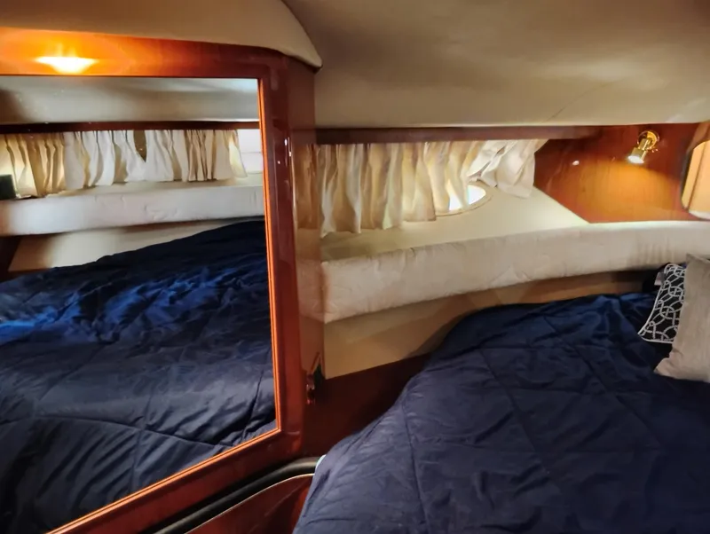 Slide: The Image of Interior cabin of 1999 Sea Ray 400 Sundancer with blue bedding and wood accents. - 36