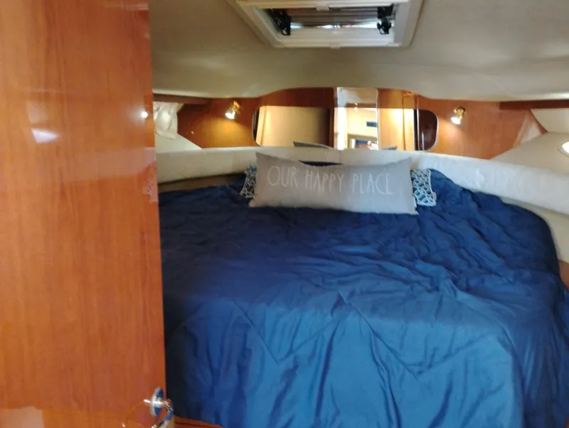 Slide: The Image of Cozy cabin interior of 1999 Sea Ray 400 Sundancer with blue bedding and decorative pillows. - 37