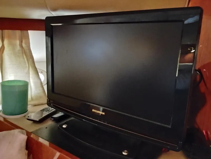 Slide: The Image of TV and remote inside 1999 Sea Ray 400 Sundancer yacht cabin. - 39