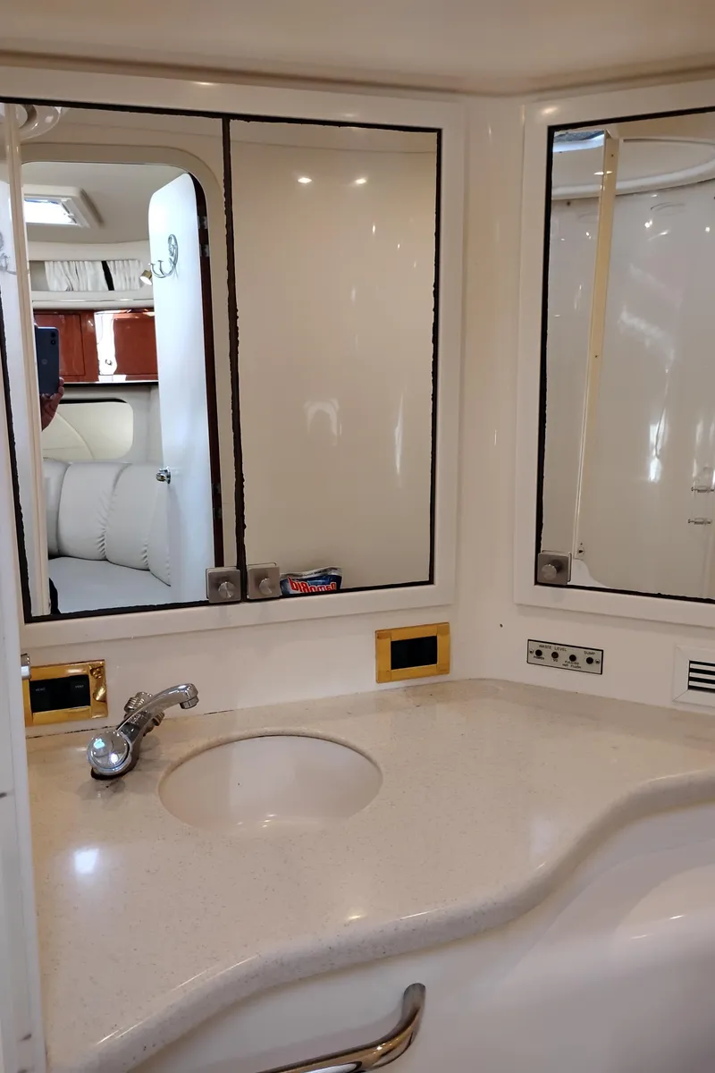 Slide: The Image of Bathroom vanity in 1999 Sea Ray 400 Sundancer yacht, featuring mirrors and a sleek countertop. - 42