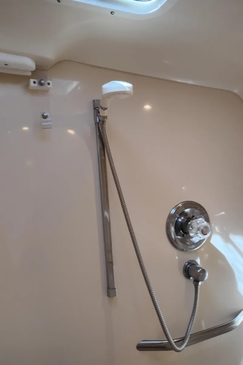 Slide: The Image of Shower area in 1999 Sea Ray 400 Sundancer yacht, featuring chrome fixtures and handheld showerhead. - 43