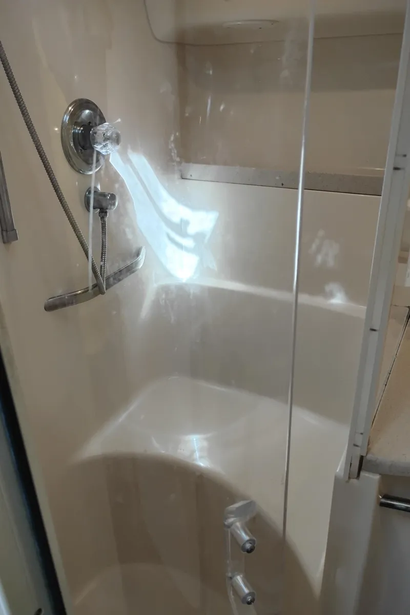 Slide: The Image of Shower area in 1999 Sea Ray 400 Sundancer yacht, featuring glass door and chrome fixtures. - 44