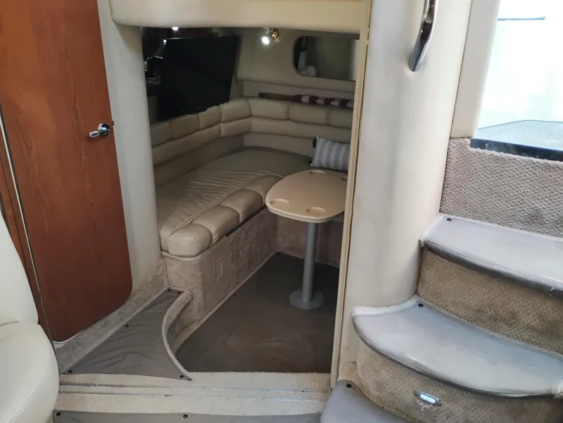 Slide: The Image of 1999 Sea Ray 400 Sundancer interior with beige seating and compact table. - 46