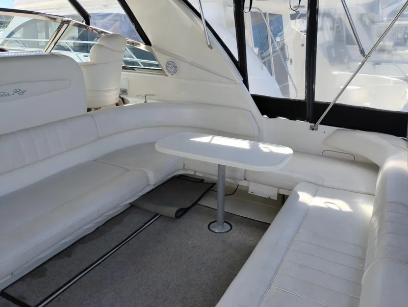 Slide: The Image of 1999 Sea Ray 400 Sundancer interior with white seating and table, showcasing luxury yacht design. - 6