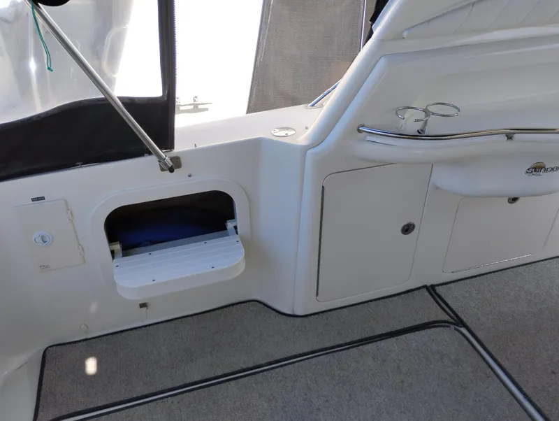 Slide: The Image of 1999 Sea Ray 400 Sundancer interior with storage compartment and cup holder. - 8