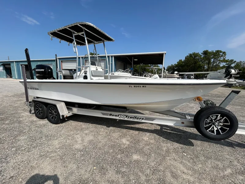 The Image of Kenner Vision 2103 boat on trailer, 2008 model, parked outdoors under clear sky. - 1