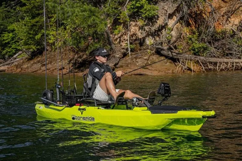 Slide: The Image of Person fishing on a 2023 Bonafide P127 kayak in a scenic lake setting. - 8