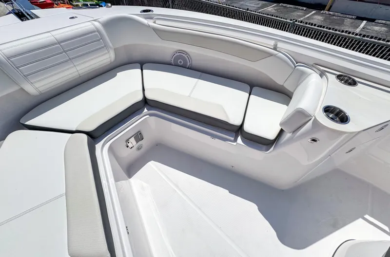 Slide: The Image of 2025 Edgewater 262CC boat interior with white cushioned seating and cup holders. - 13