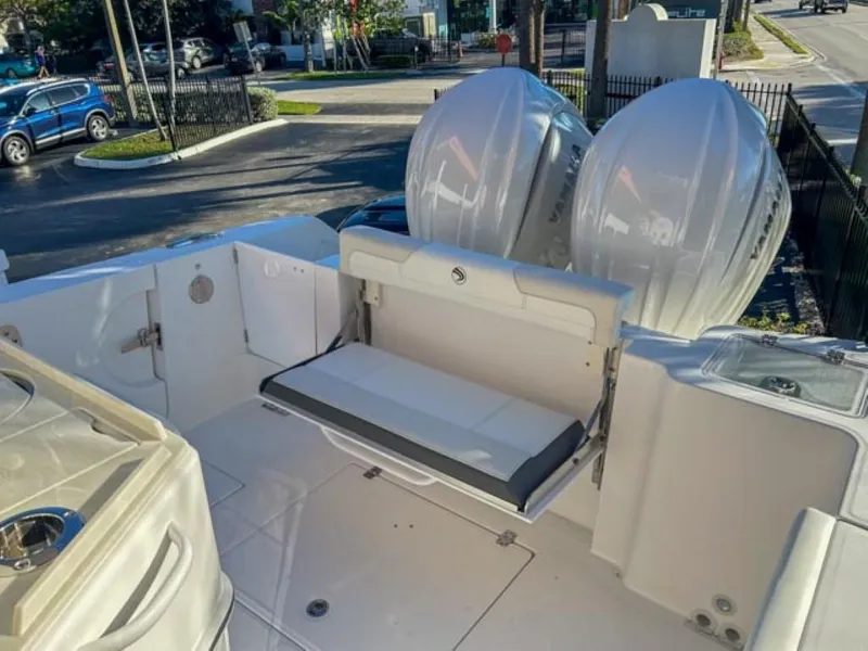 Slide: The Image of 2025 Edgewater 262CC boat with dual engines and foldable seating in a marina setting. - 22