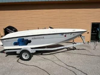 Slide: The Image of 2017 Bayliner Element E16 boat on trailer, parked outside a building. - 1