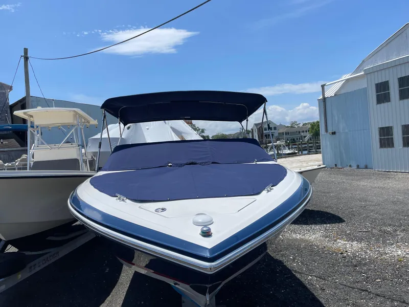 The Image of 2004 Cobalt 226 boat with blue cover, parked outdoors on a sunny day. - 0