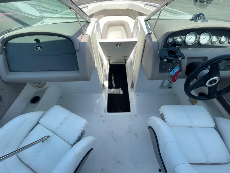 Slide: The Image of Interior of a 2004 Cobalt 226 boat with white seating and dashboard controls. - 10