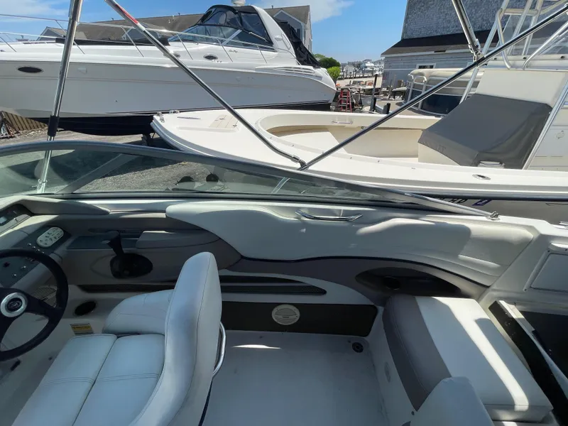 Slide: The Image of Interior view of a 2004 Cobalt 226 boat with white seating and dashboard. - 16