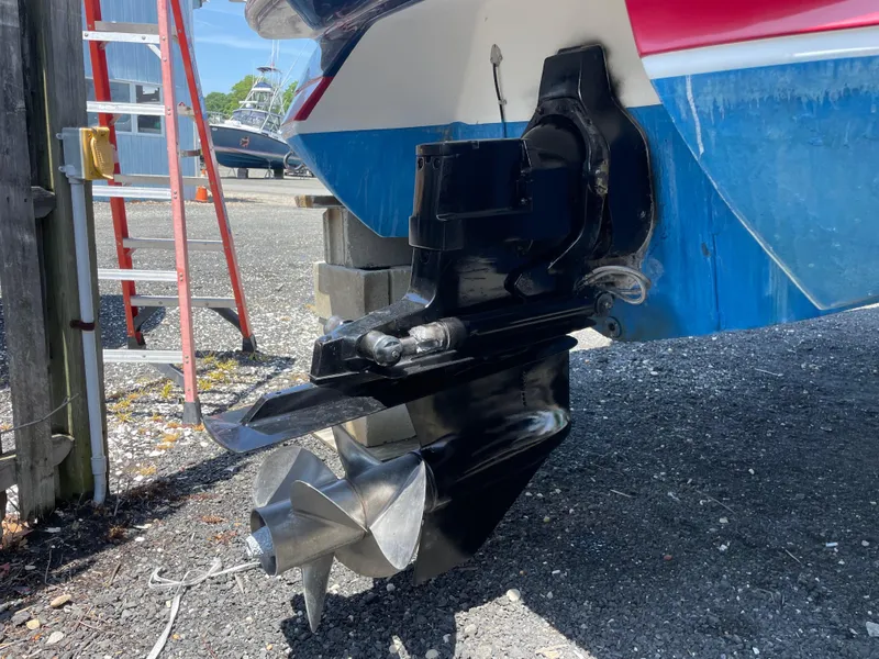 Slide: The Image of 2004 Cobalt 226 boat with visible propeller and outdrive, parked on gravel. - 17