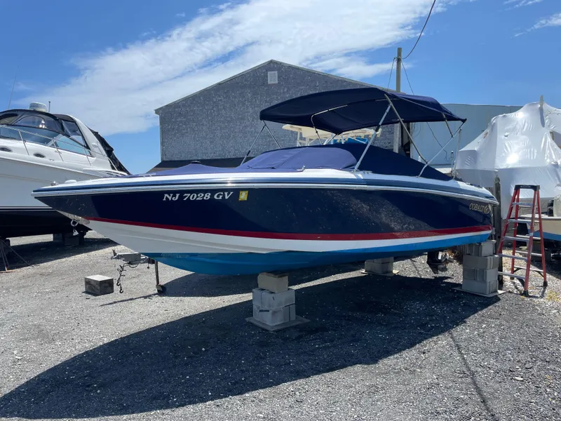 Slide: The Image of 2004 Cobalt 226 boat on blocks, blue hull, outdoor storage. - 19