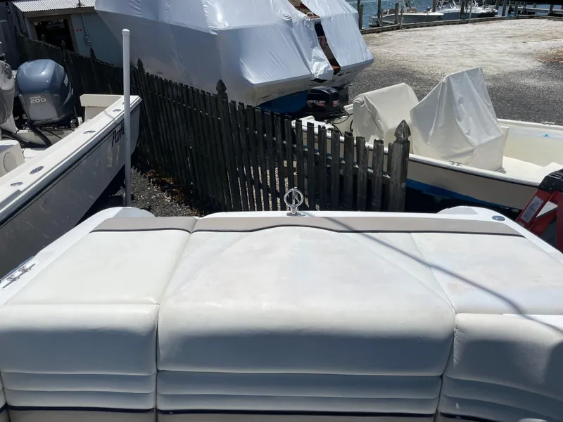 Slide: The Image of 2004 Cobalt 226 boat in storage, surrounded by other covered boats and a wooden fence. - 22