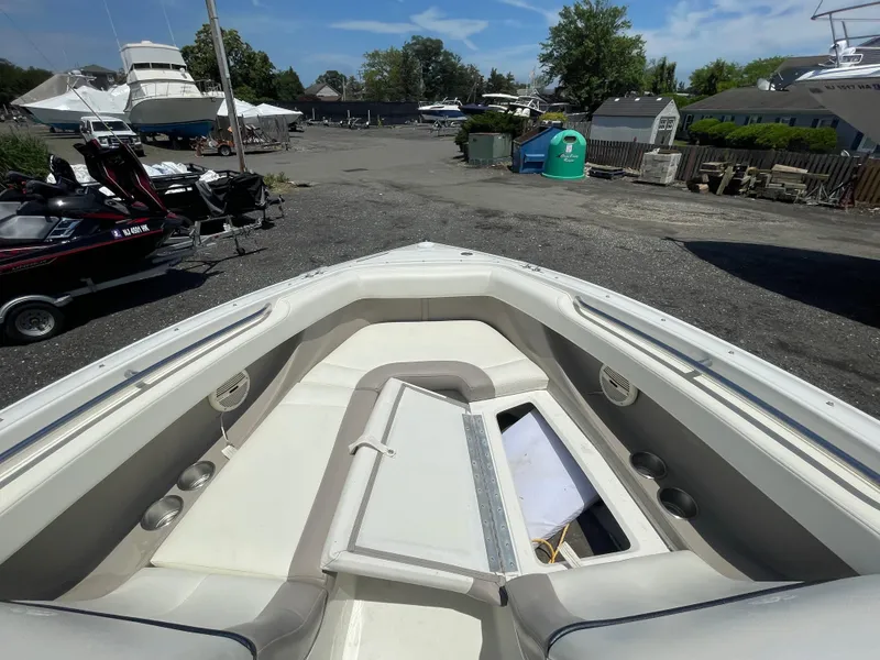 Slide: The Image of 2004 Cobalt 226 boat interior with open storage compartment, docked near other boats. - 4