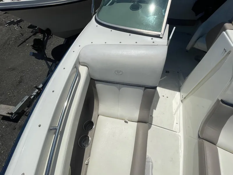 Slide: The Image of 2004 Cobalt 226 boat interior with white and gray seating, cup holders, and windshield. - 5