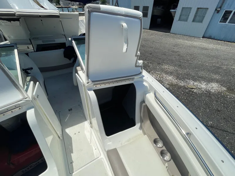 Slide: The Image of 2004 Cobalt 226 boat interior with open storage compartments and cup holders. - 6