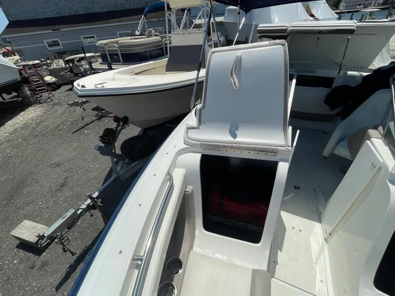 Slide: The Image of 2004 Cobalt 226 boat interior with open storage compartments and seating area. - 7