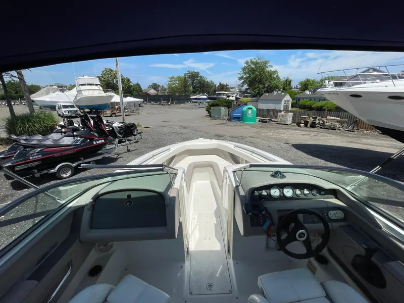 Slide: The Image of 2004 Cobalt 226 boat interior with dashboard, parked near other boats and jet skis. - 8