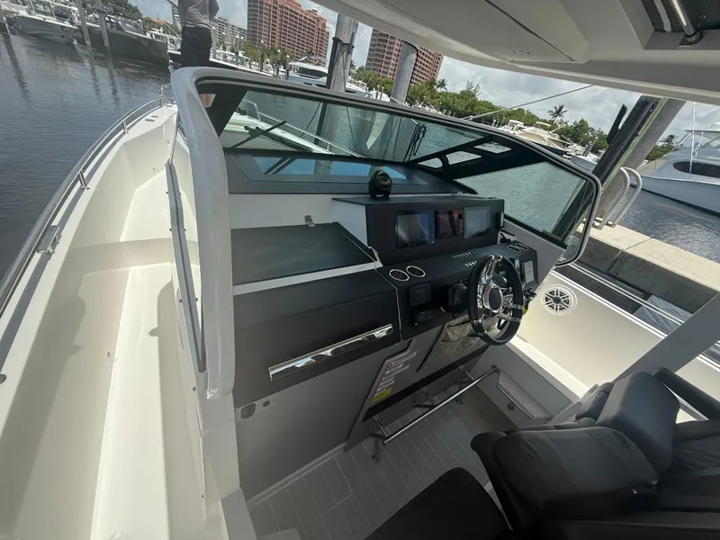 Slide: The Image of 2017 Axopar 37 Sun Top boat helm with modern controls and steering wheel. - 22