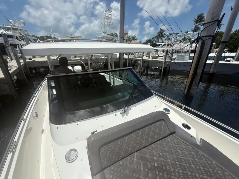 Slide: The Image of 2017 Axopar 37 Sun Top boat docked at marina under a cloudy sky. - 23