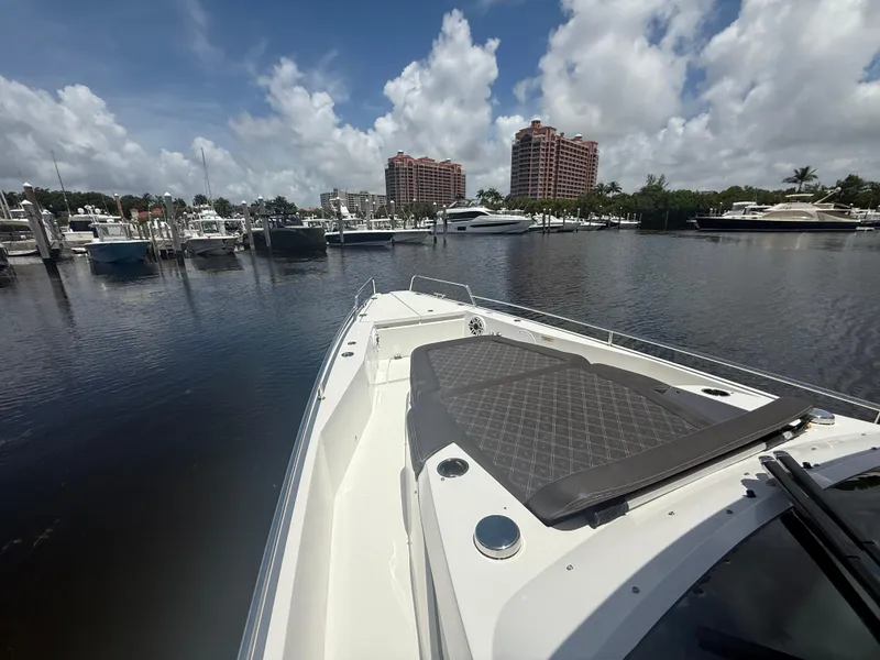 Slide: The Image of 2017 Axopar 37 Sun Top boat docked in a marina under a partly cloudy sky. - 24
