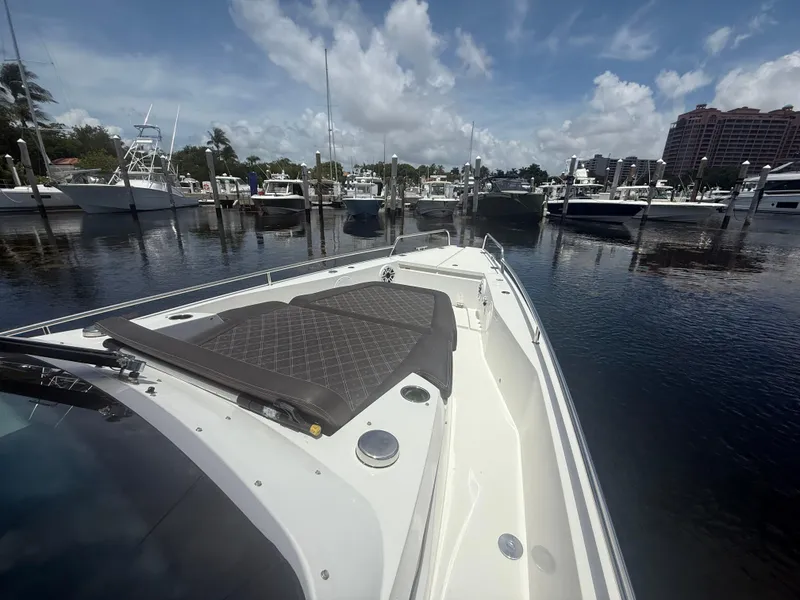 Slide: The Image of 2017 Axopar 37 Sun Top boat docked in a marina under a partly cloudy sky. - 25