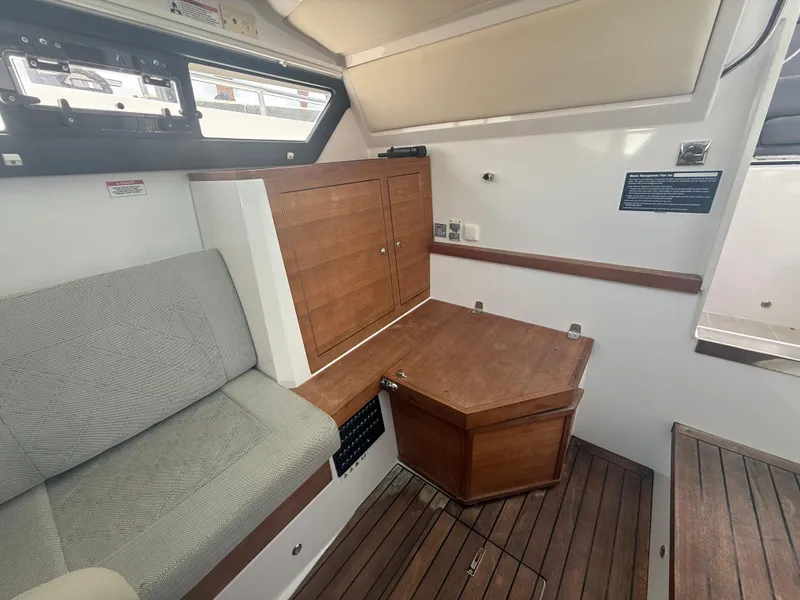 Slide: The Image of 2017 Axopar 37 Sun Top interior with wooden cabinetry and cushioned seating. - 27