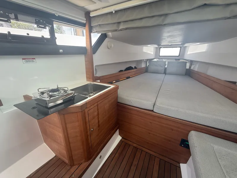 Slide: The Image of Interior of 2017 Axopar 37 Sun Top with kitchenette and cozy sleeping area. - 29