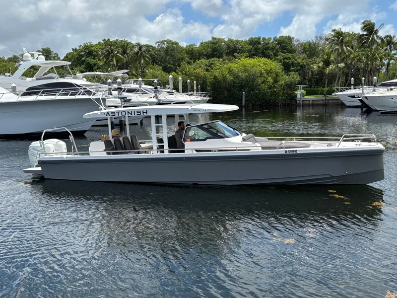 Slide: The Image of 2017 Axopar 37 Sun Top boat on water, surrounded by lush greenery and other yachts. - 3