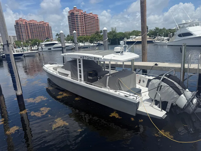 Slide: The Image of 2017 Axopar 37 Sun Top boat docked in a marina with buildings in the background. - 5