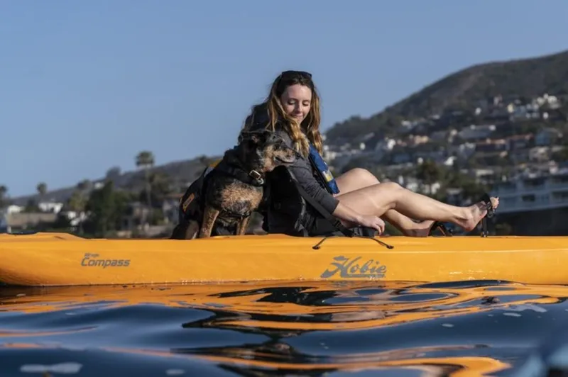 Slide: The Image of Woman and dog kayaking on 2025 Hobie Mirage Compass in scenic waters. - 5