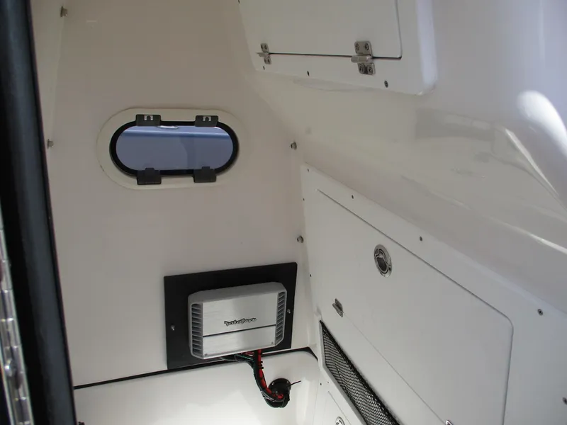 Slide: The Image of Interior of 2024 Blue Wave 2800 Makaira boat, featuring storage compartments and a small window. - 15