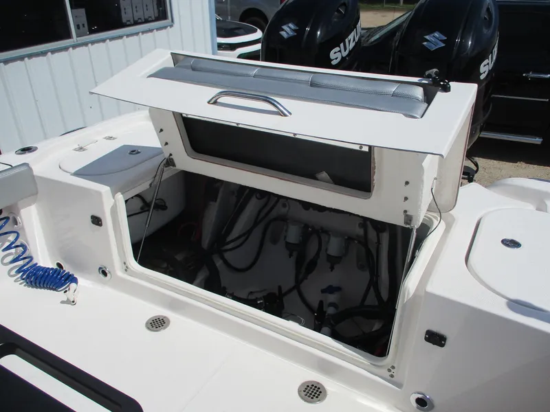 Slide: The Image of 2024 Blue Wave 2800 Makaira boat with open storage compartment and visible engine components. - 18